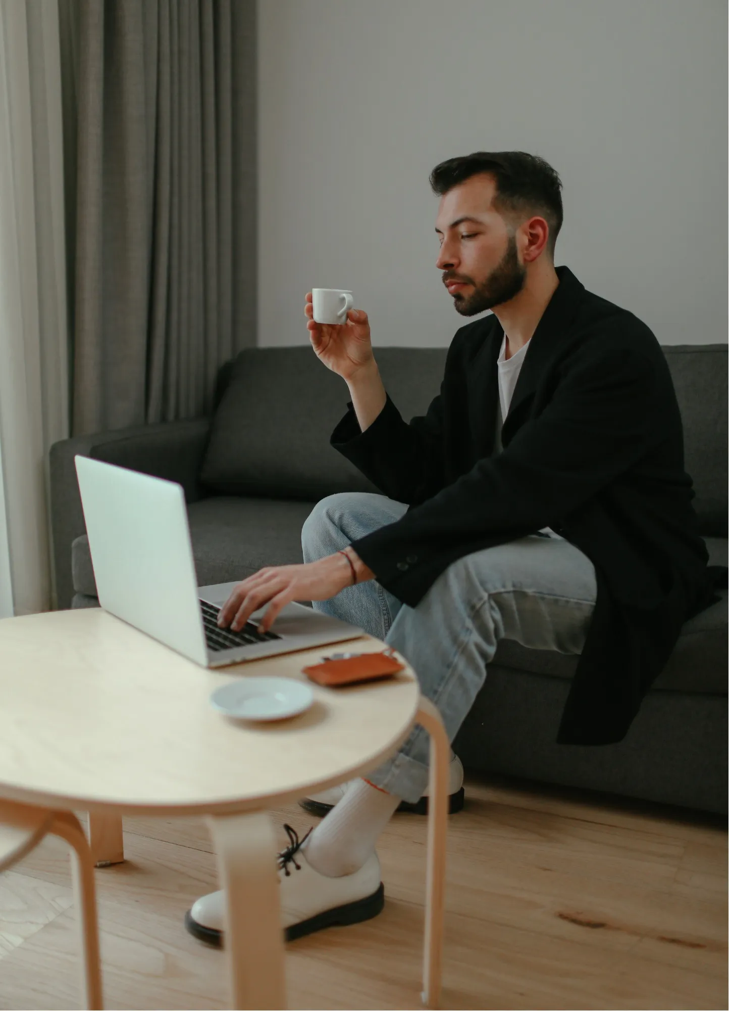 Hráč pri online tréningu s notebookom doma na gauči